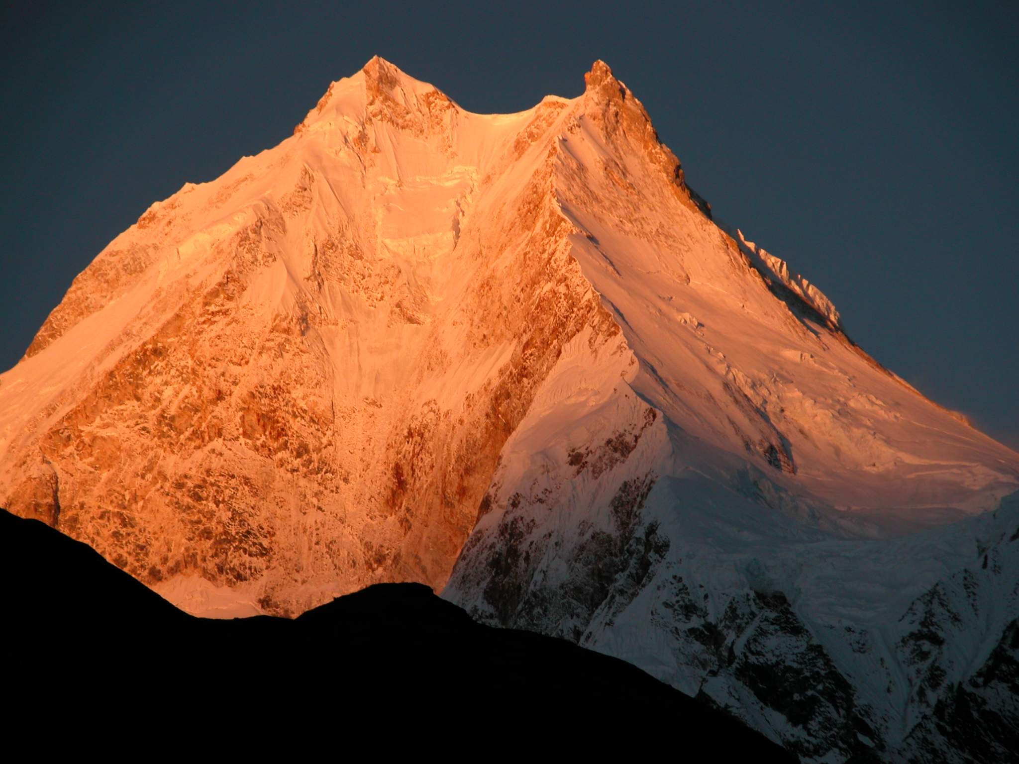 Manaslu 07 01 Manaslu Sunrise From Syala I waited with anticipation for the sun to rise and hit the mountains. Wow! The subtle changes of the light on Manaslu are terrific, turning from grey to pink to orange to yellow and then to white, all within a few minutes.
